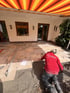 Handwerker von Gartenglück verlegt großformatige beige Natursteinplatten auf einer Terrasse mit Splittbett.