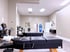 Black leather chiropractic adjustment tables in a brightly lit medical clinic with neutral walls and tile floors.