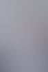 Lächelnde Frau mit langen, hellbraunen Haaren im weißen Poloshirt steht in einem Büro vor einem Schreibtisch.