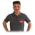 Marvin Gehr im grauen Polo-Shirt mit "Gehr" Logo lächelt und hat die Hände in den Hüften.