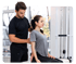 Physical therapist adjusting a woman's posture during a rehabilitation session.