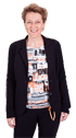 Eine lächelnde Frau mit kurzen, lockigen Haaren, schwarzem Blazer und T-Shirt mit orangefarbenem und schwarzem Muster.
