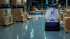 Autonomer Rosiwit Reinigungsroboter Titan 810 reinigt den Boden in einem Lager mit Regalen
