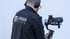 Mann in schwarzer Jacke mit "Lenger Media" Logo filmt mit professioneller Kamera und Gimbal.