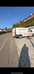 Weißer Transporter mit „Das ElektroWerk“ und orangefarbenem Blitzlogo parkt am Straßenrand.