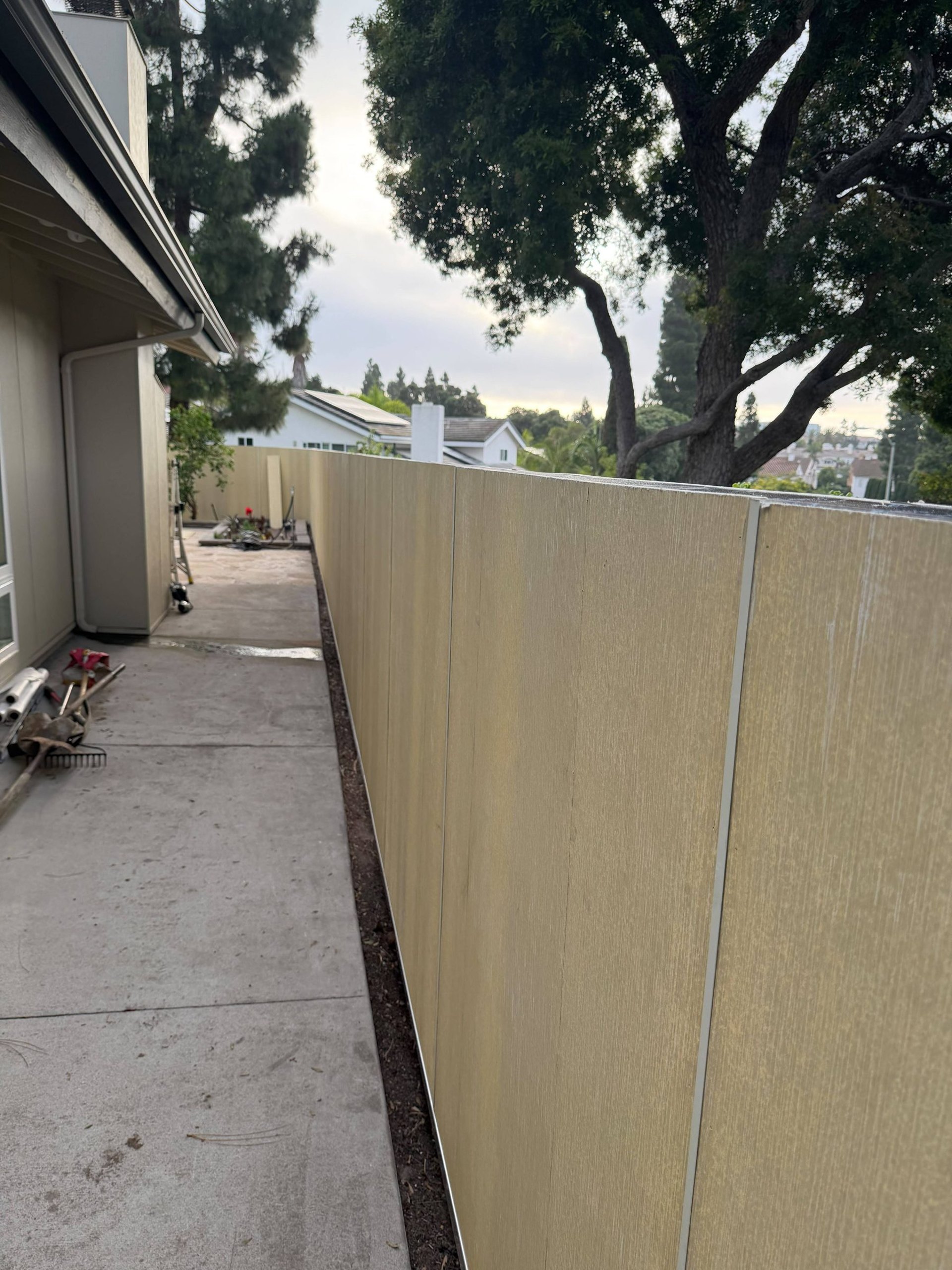 Hardie panel fence installation in progress beside a San Diego home