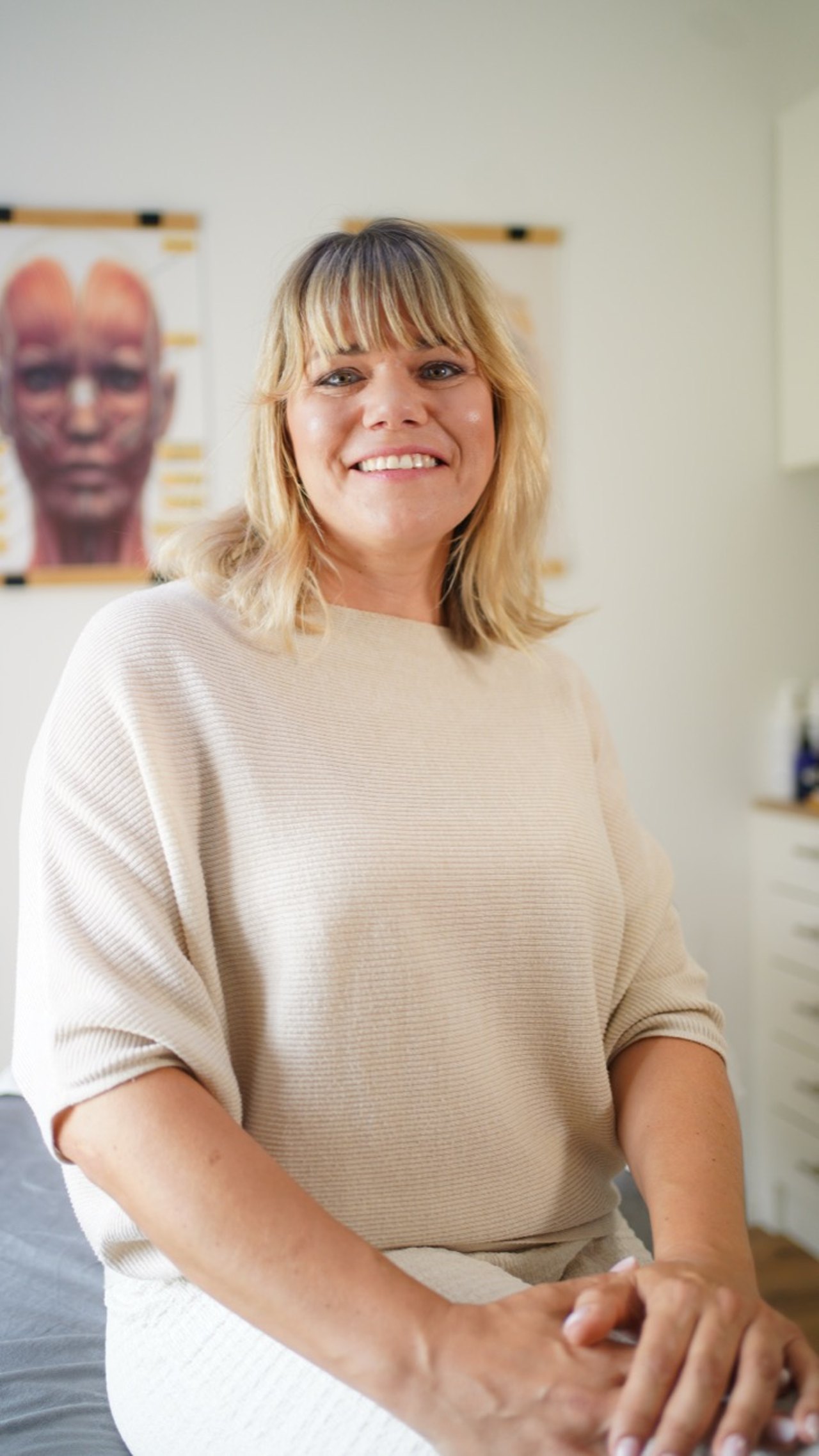 Anja Mayer vor dem Anatomie-Poster in ihrem Studio