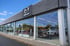 Mazda Autohaus mit großen Glasfenstern, die mehrere Neuwagen im Showroom reflektieren.