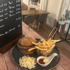 Ein Hamburger-Menü mit Pommes frites, Krautsalat und Dips auf einem Holztisch.