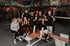 Ten people, men and women, in a gym posing with some making fists.
