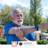 Smiling older man in blue shirt stretching arm outdoors, promoting autoimmune disease relief.