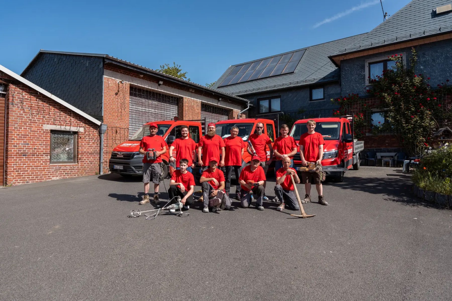 Das Team von Schmidt Hochbau mit den Firmenfahrzeugen vor dem Bauhof in Rennerod
