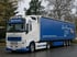 Weißer Volvo LKW mit blauem Planenauflieger der Spedition Eckert-Transporte parkt vor herbstlichen Bäumen.