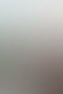 Lächelnde junge Frau mit blondem Haar sitzt an einem Tisch; im Hintergrund leuchtet ein Neonzeichen "STEUERBERATUNG SCHUBERT".
