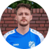 Porträt eines Mannes im blauen und weißen Trikot des SV Emmerich-Vrasselt 1912 vor einer roten Backsteinmauer.