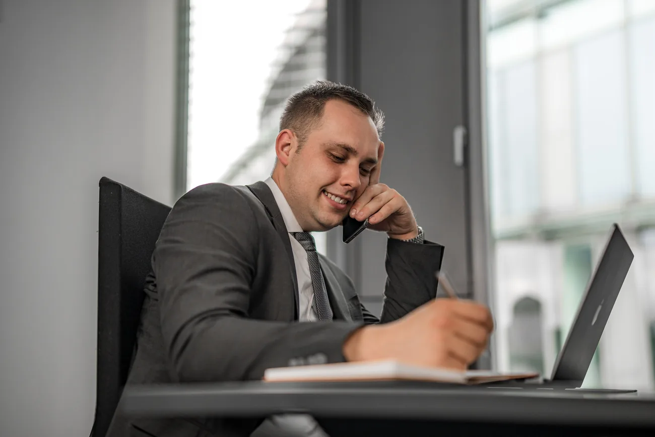 Alexander Pfeifer telefoniert und notiert am Laptop