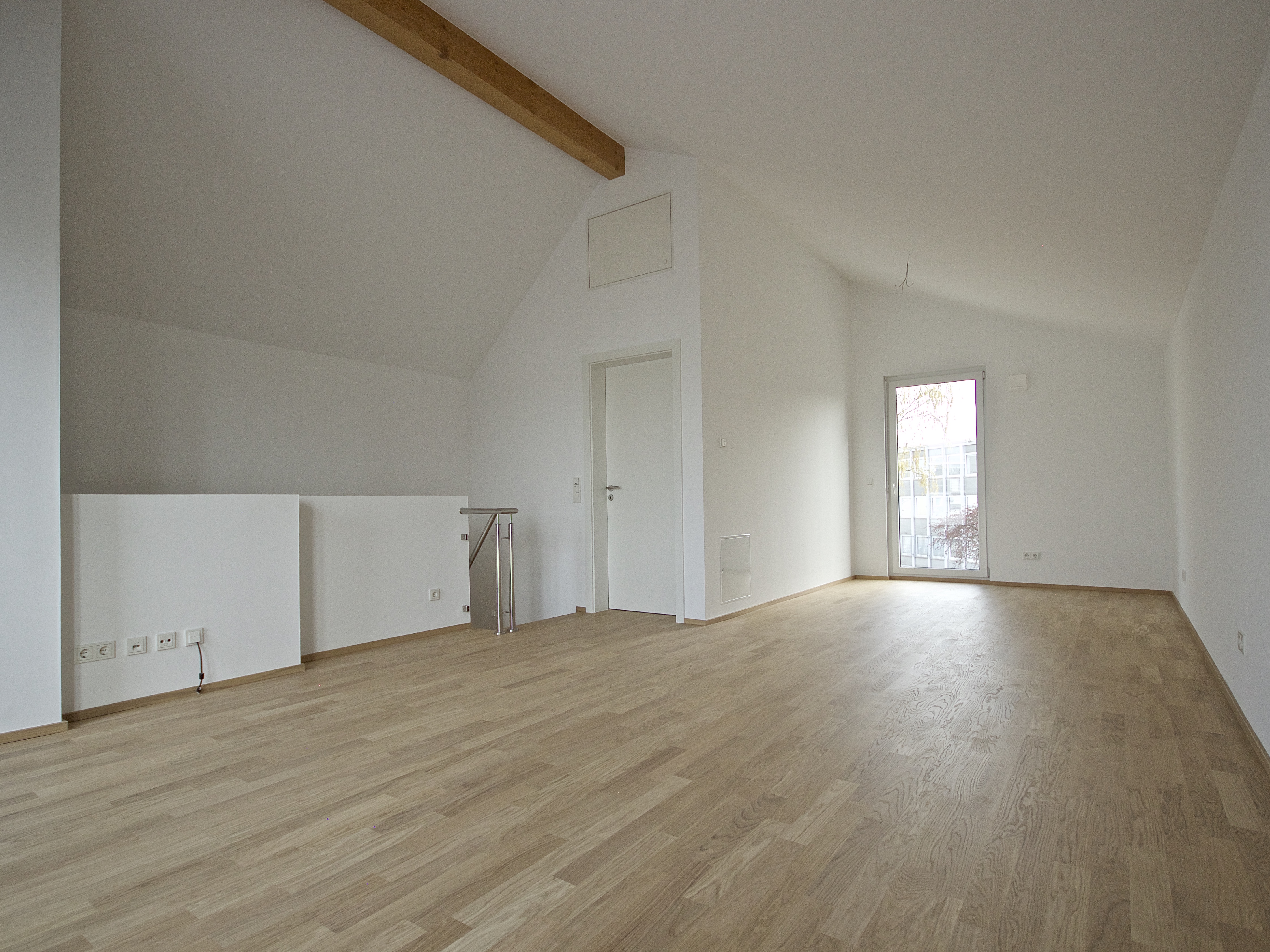 Wohnquartier Am Klosterpark – heller Wohnraum im Dachgeschoss mit Parkettboden
