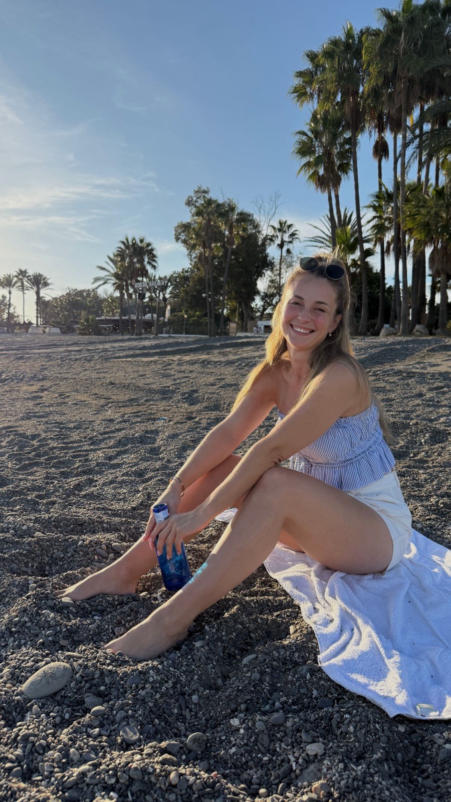 Tatjana Schäfer sitzt lachend am Strand
