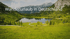 Bergsee in einer grünen Landschaft mit schneebedeckten Bergen; Text: Wanderurlaub in Deutschland.