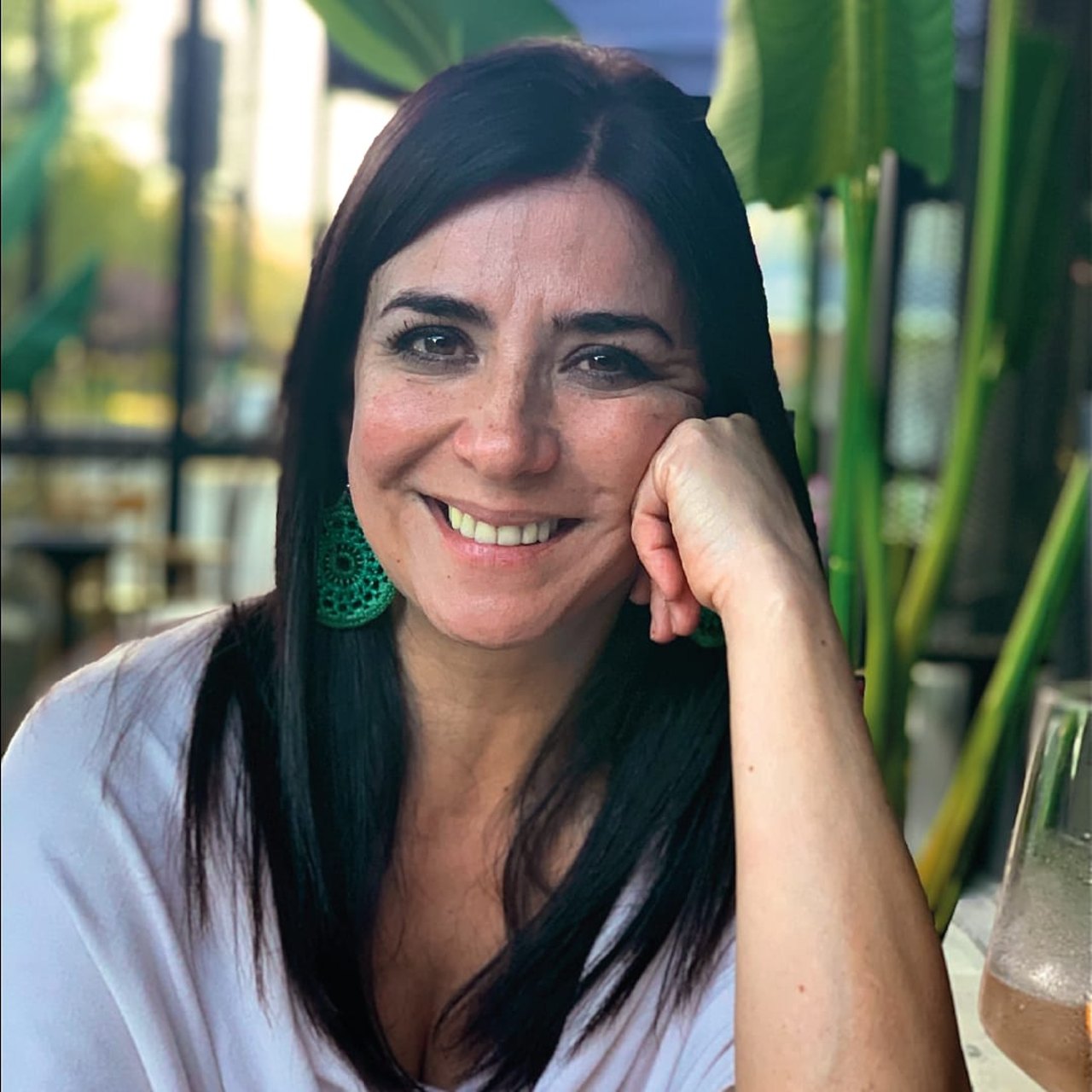 Psicóloga Jimena Guerrero, sonriendo, con aretes verdes