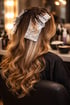 Frau mit langen gewellten Haaren, die Foliensträhnen zum Färben in einem Friseursalon hat.