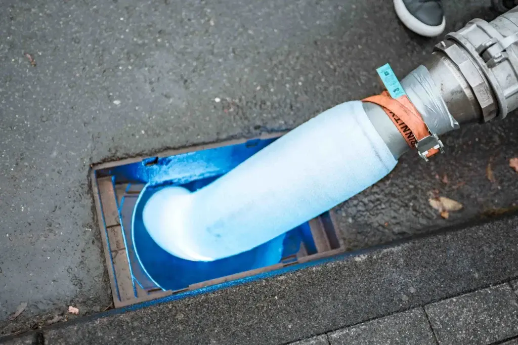 Blauer Schlauchliner wird in einen Abwasserschacht eingebracht