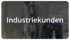 Zwei Arbeiter in einer Fabrikhalle betrachten ein Tablet unter dem Schriftzug Industriekunden.