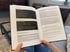 Hände halten ein aufgeschlagenes Buch mit Textpassagen zu Reframing-Strategien und Übungen gegen Zukunftsangst.
