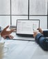 Zwei Personen diskutieren Inhalte auf einem Laptop-Bildschirm, der ein Dokumentenmanagement-System anzeigt - Katastrophenschutz-Software Notfall- und Krisenmanager (NKM®).
