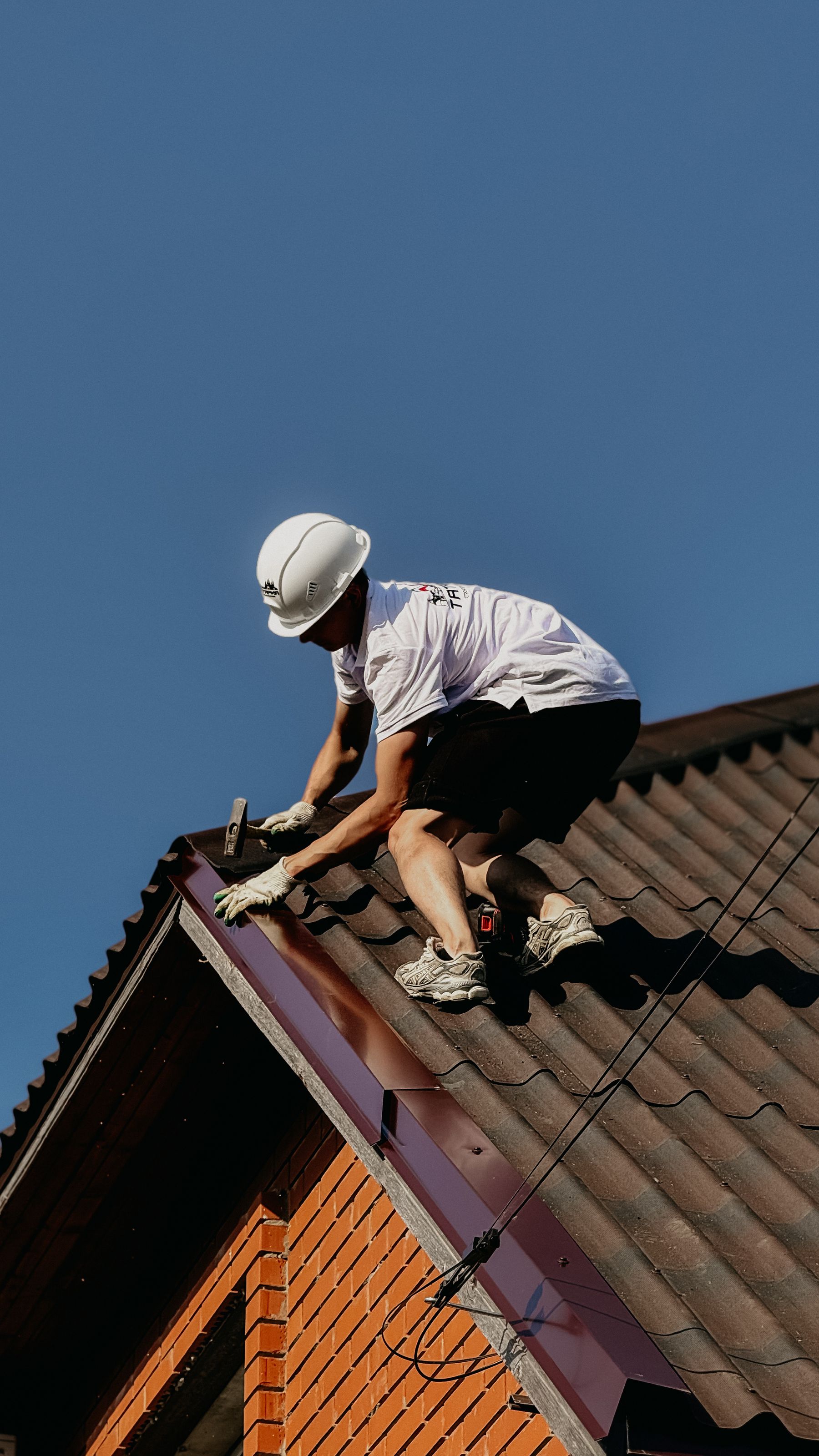 Roofer in safety gear surveying the surface of a roof