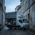 Lieferwagen mit geöffneter Ladeklappe bei der Warenannahme eines Betriebs, gestapelte Kisten im Laderaum