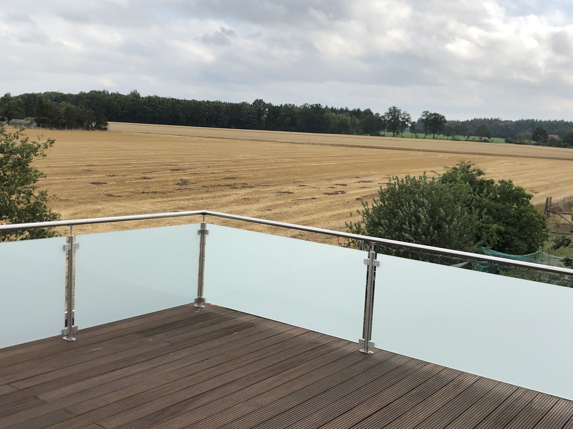 Terrassengeländer aus Edelstahl mit Glasfüllung mit Blick über Felder
