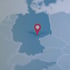 Roter Standort-Pin auf einer blauen Deutschlandkarte.