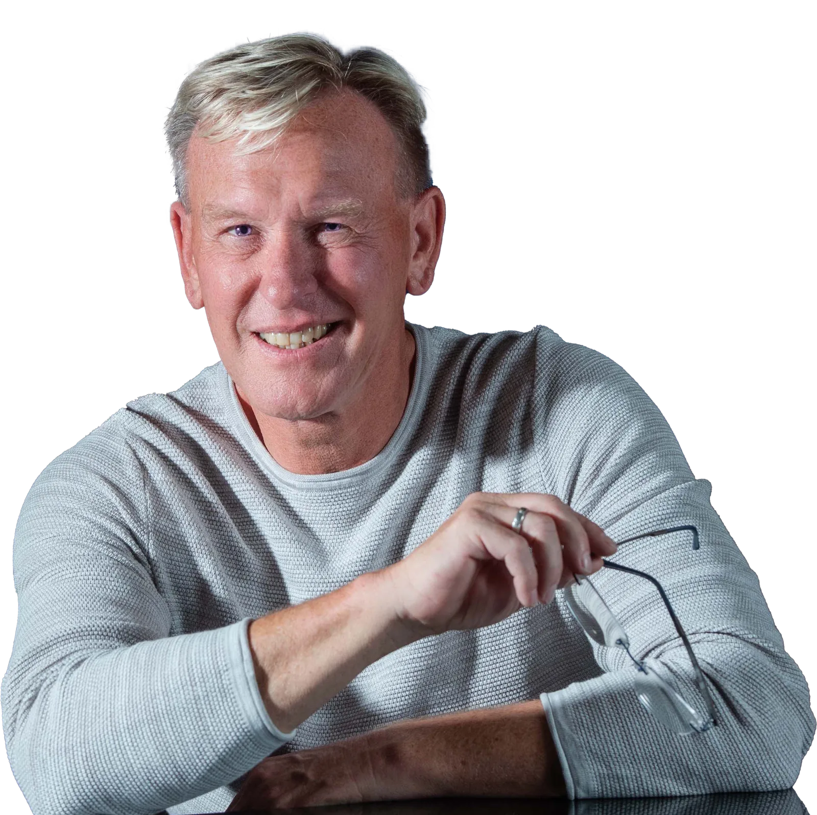 Dirk Rabis, Medienstratege, lächelt in die Kamera und hält eine Brille in der Hand
