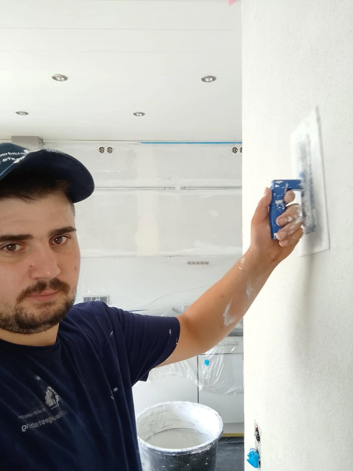 Mitarbeiter reibt frischen Putz an der Wand glatt