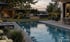 Moderner Garten mit Pool, Whirlpool, beleuchtetem Poolhaus und Loungebereich bei Dämmerung von Mayr Schwimmbad-Technik.