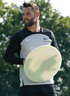Ein Mann in einem Sport-T-Shirt mit der Aufschrift „TSA since 2020“ hält eine weiße Frisbee.