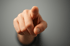 Eine Hand zeigt mit dem Zeigefinger direkt auf den Betrachter.