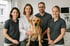 Tierärzteteam mit Labrador auf dem Untersuchungstisch – engagierte Tierärzte und tiermedizinische Fachangestellte in moderner Tierarztpraxis mit Fokus auf Teamarbeit und Patientenwohl