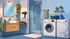 Ein blaues Badezimmer mit Waschbecken, Spiegel, Dusche, Waschmaschine und Trockner.