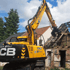 Gelber JCB-Bagger reißt ein altes Backsteinhaus mit freiliegendem Dachgebälk ab.