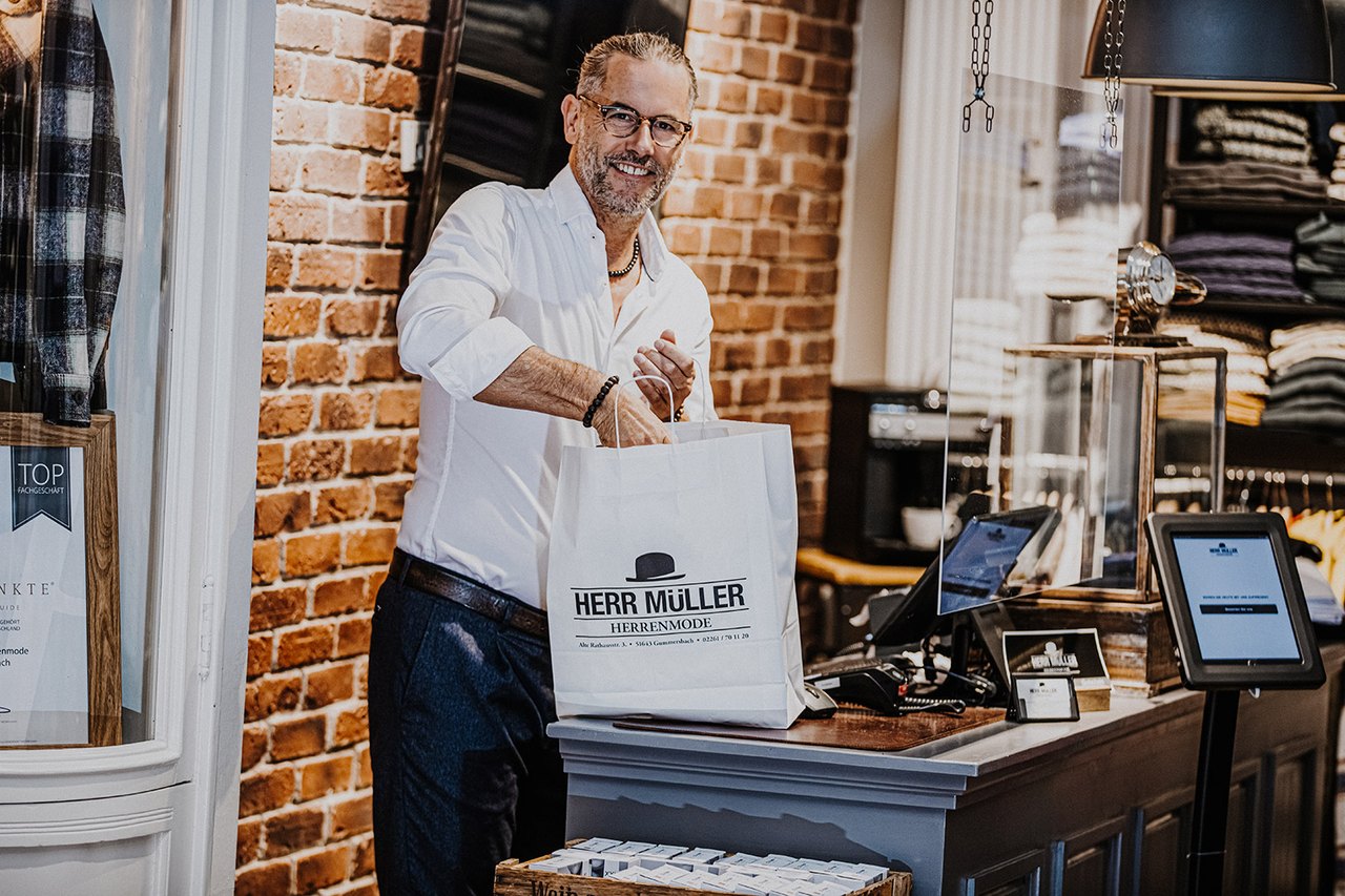 Torsten Müller packt einen Einkauf an der Theke ein