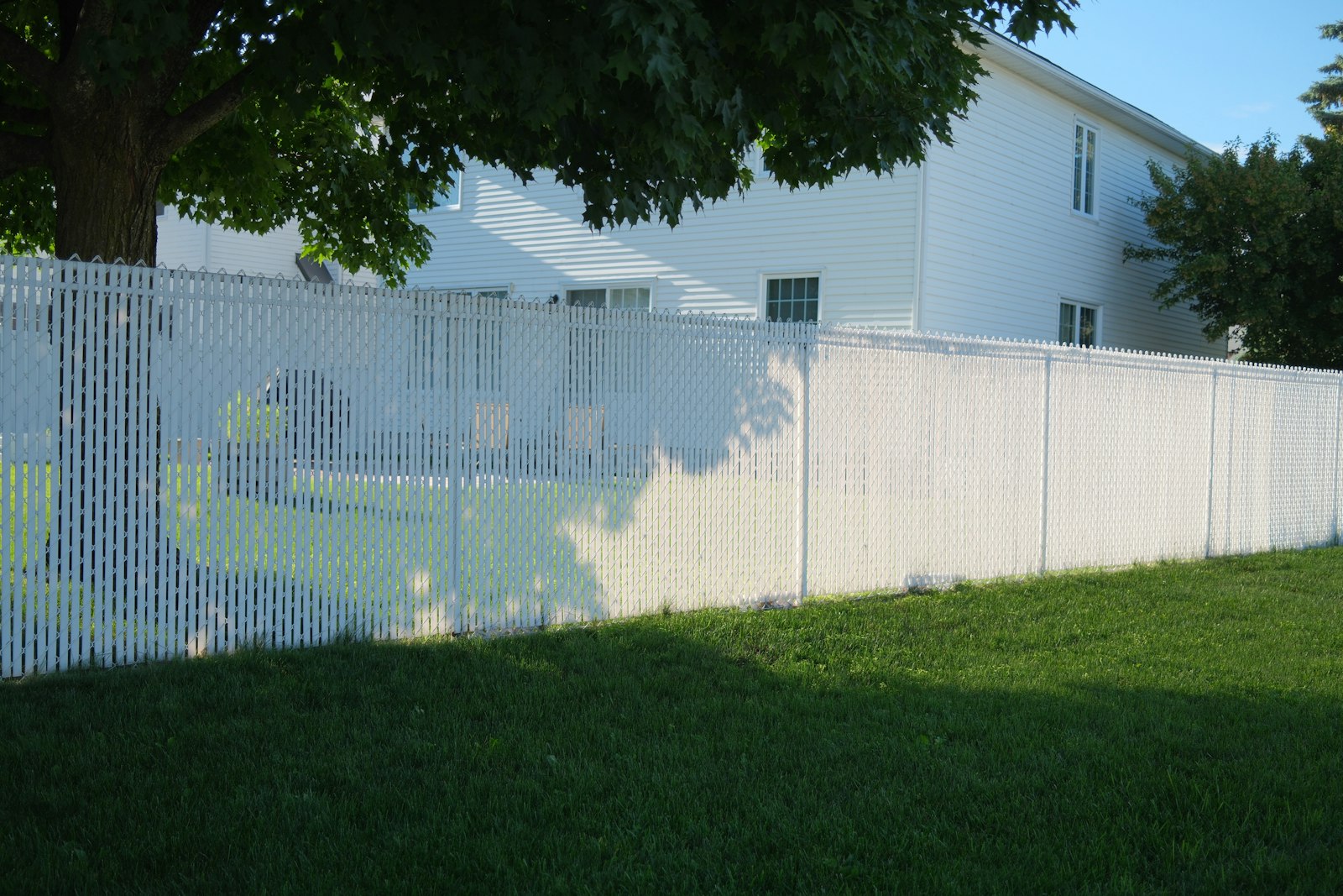 White vinyl privacy fence panels installed along a Columbia, Maryland backyard