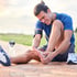 Man holding his painful ankle after getting injured during sports.