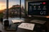 Büro mit Blick auf Salzburg; Monitor zeigt „YouTube als Wachstumsmotor für B2B-Unternehmen“ mit Strategie-Grafiken.