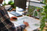 Person am Schreibtisch mit Maus und Stift, Landschaftsarchitekturpläne auf Papier und Monitor.