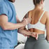 A practitioner examining a patient's back.