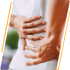 Person grips their lower back seeking sciatica and nerve pain relief.