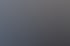 Eine lächelnde Frau mit Headset tippt an einem Schreibtisch auf einer Tastatur vor einem Computermonitor.