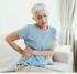 Elderly Woman holding her lower back in pain.